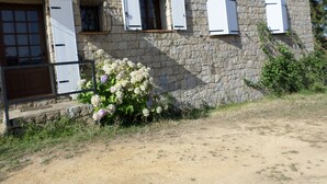 A stone building with a rustic appearance, featuring a wooden door and windows with shutters. - Charming house near the sea South Corsica (Sollacaro)