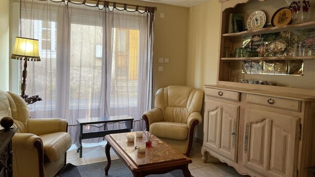 Ein Wohnzimmer mit Sofa, Sessel, Couchtisch und einer Kommode mit Dekoration.