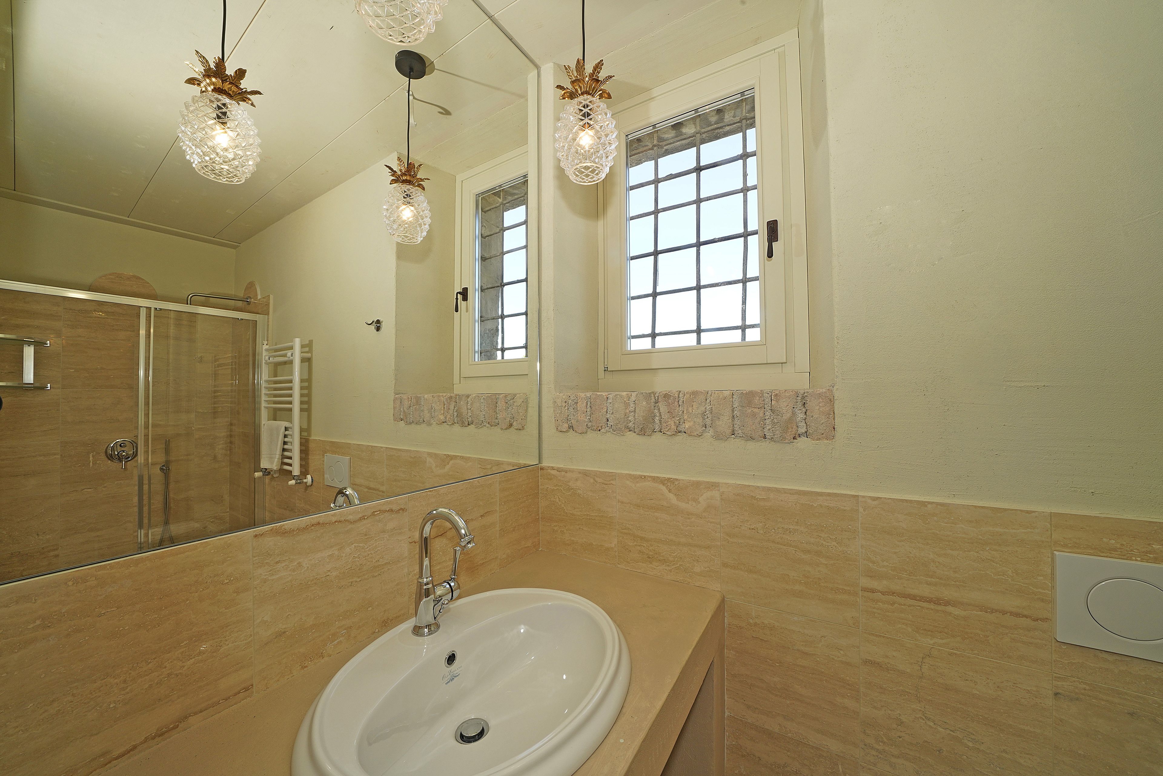 Un bagno con uno specchio grande, un lavandino e una doccia.