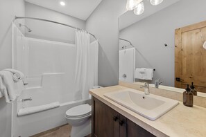 A modern bathroom with a shower, toilet, and sink.