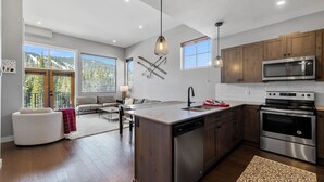 Una cocina moderna con una isla grande, electrodomésticos de acero inoxidable y armarios de madera.