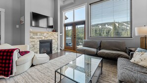 Una sala de estar moderna con chimenea, una mesa de centro de vidrio y un sofá.
