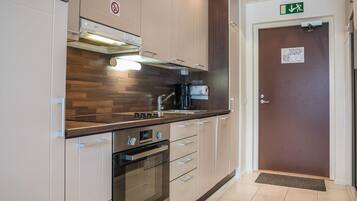 Een koelkast, een magnetron, een vaatwasser, kookgerei, borden en bestek