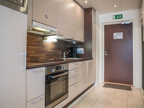 Een koelkast, een magnetron, een vaatwasser, kookgerei, borden en bestek