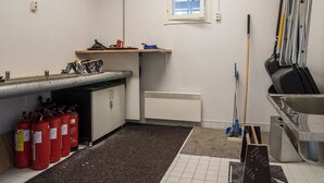 Een kleine kitchenette met een gootsteen, een raam en een brandblusser.