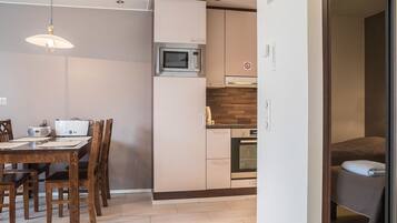 Een koelkast, een magnetron, een vaatwasser, kookgerei, borden en bestek