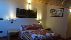 A room with a bed, bedside tables, and wall-mounted lights. - B&B Marameo (Udine)