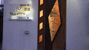 A building entrance with a sign reading "Maramco" and a large number "64112" above the door. - B&B Marameo (Udine)