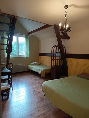 A room with a loft bed, a small bed, a chair, a ladder, and a window with curtains. - GITE WITH SWIMMING POOL, ping pong, 45 min le mans, located alpes mancelles (MONT SAINT JEAN)