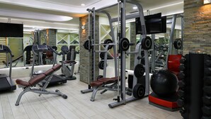 A gym with various exercise equipment, including a bench press, weight machines, and a large exercise ball.
