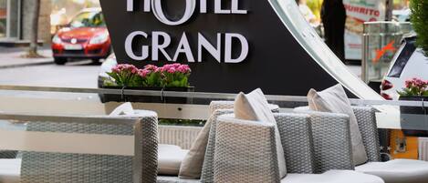 A hotel sign with outdoor seating.