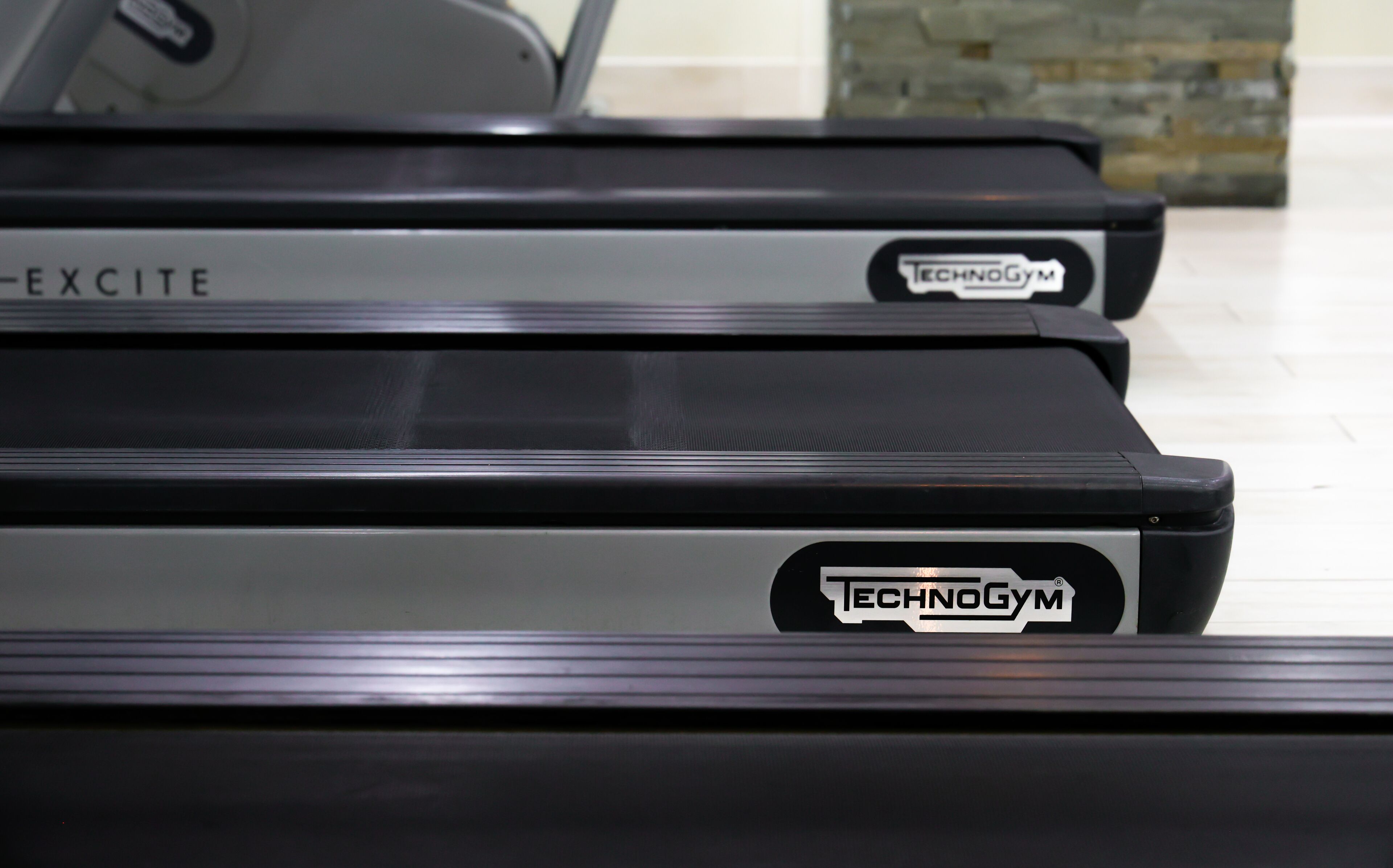A row of treadmills with the brand "TECHNOGYM" visible on the front.