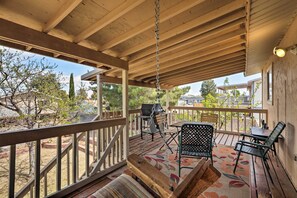 A covered outdoor patio with a wooden ceiling, a swing chair, a table with chairs, and a grill. - Walk to Rim View Trail: Page Home w/ Deck & Yard (Page)