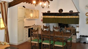 A rustic kitchen with wooden cabinets, a dining table with chairs, and a hanging light fixture. - Lovely apartment for 6 people with pool, WIFI, TV and pets allowed, close to San Gimignano (Varna)