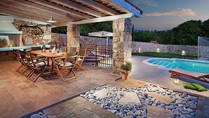 An outdoor patio with a pool, stone pillars, and a covered dining area. - Vacation home Bea by Interhome (Rabac/Sveti Lovrec Labinski)