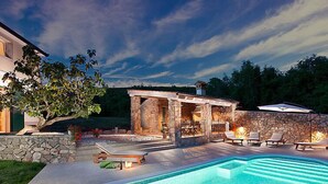 A swimming pool with lounge chairs and a stone structure with a fire feature. - Vacation home Bea by Interhome (Rabac/Sveti Lovrec Labinski)
