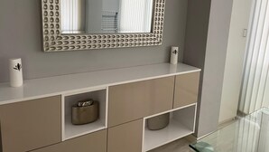 Ein modernes Badezimmer mit Waschtisch, Spiegel und Ablageschränken.