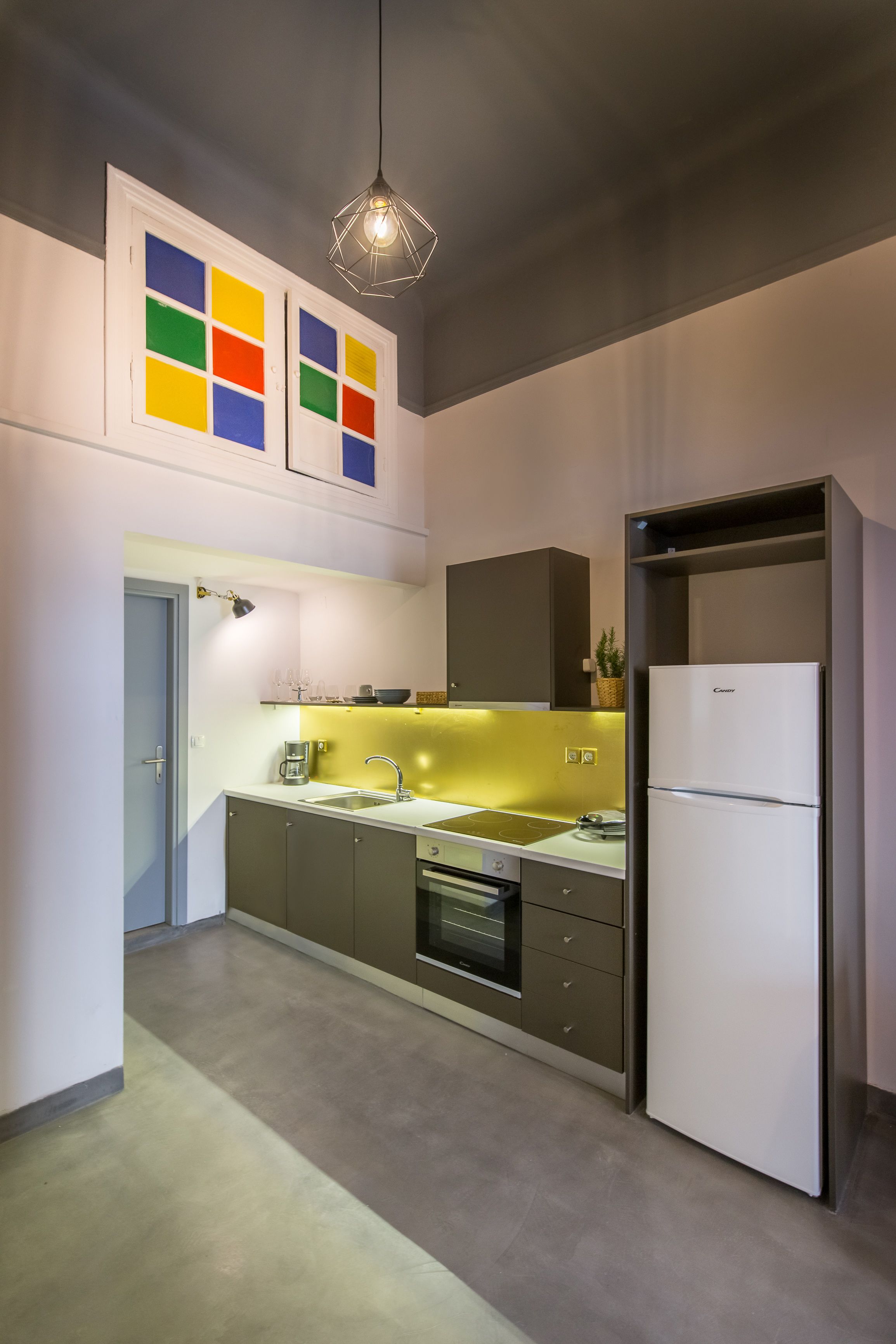 A modern kitchen with a built-in oven, a refrigerator, and a countertop with a sink.