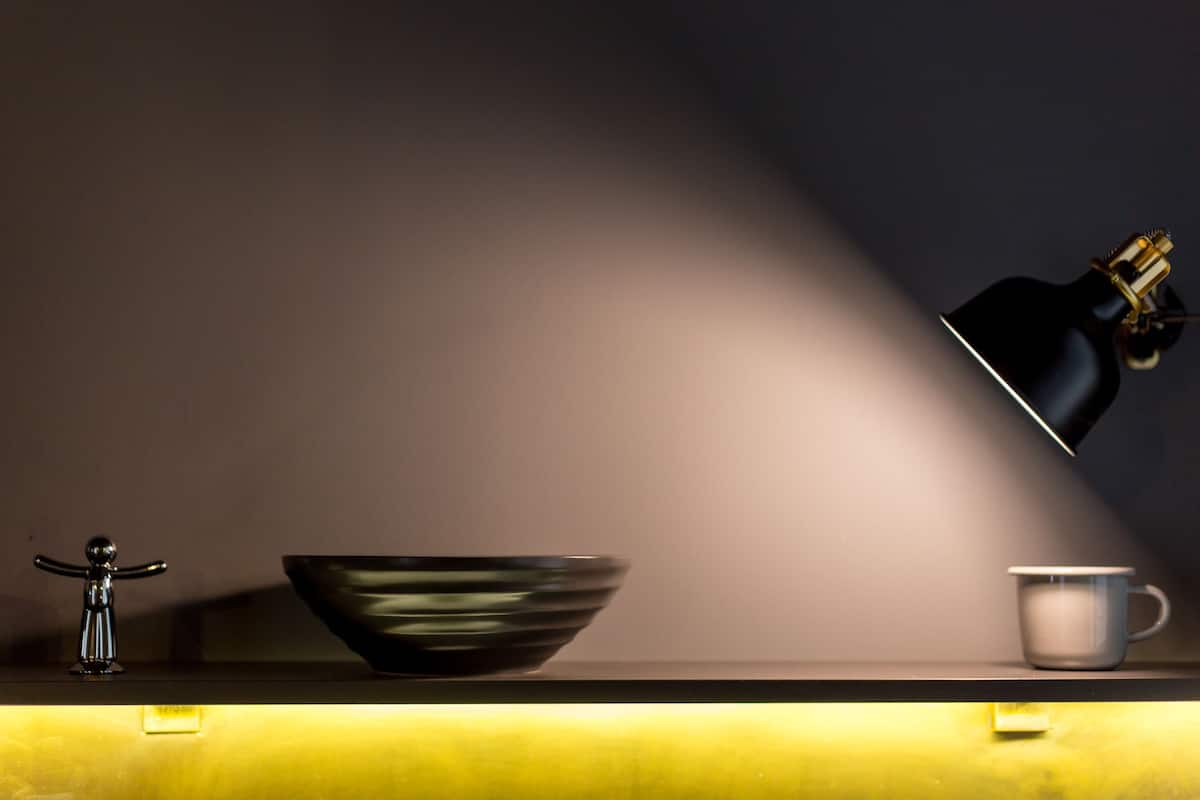 Eine Küchenarbeitsplatte mit einer Schüssel, einer Tasse und einer Lampe.