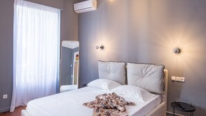 Un dormitorio moderno con una cama grande, suelo de madera y una lámpara en el techo.