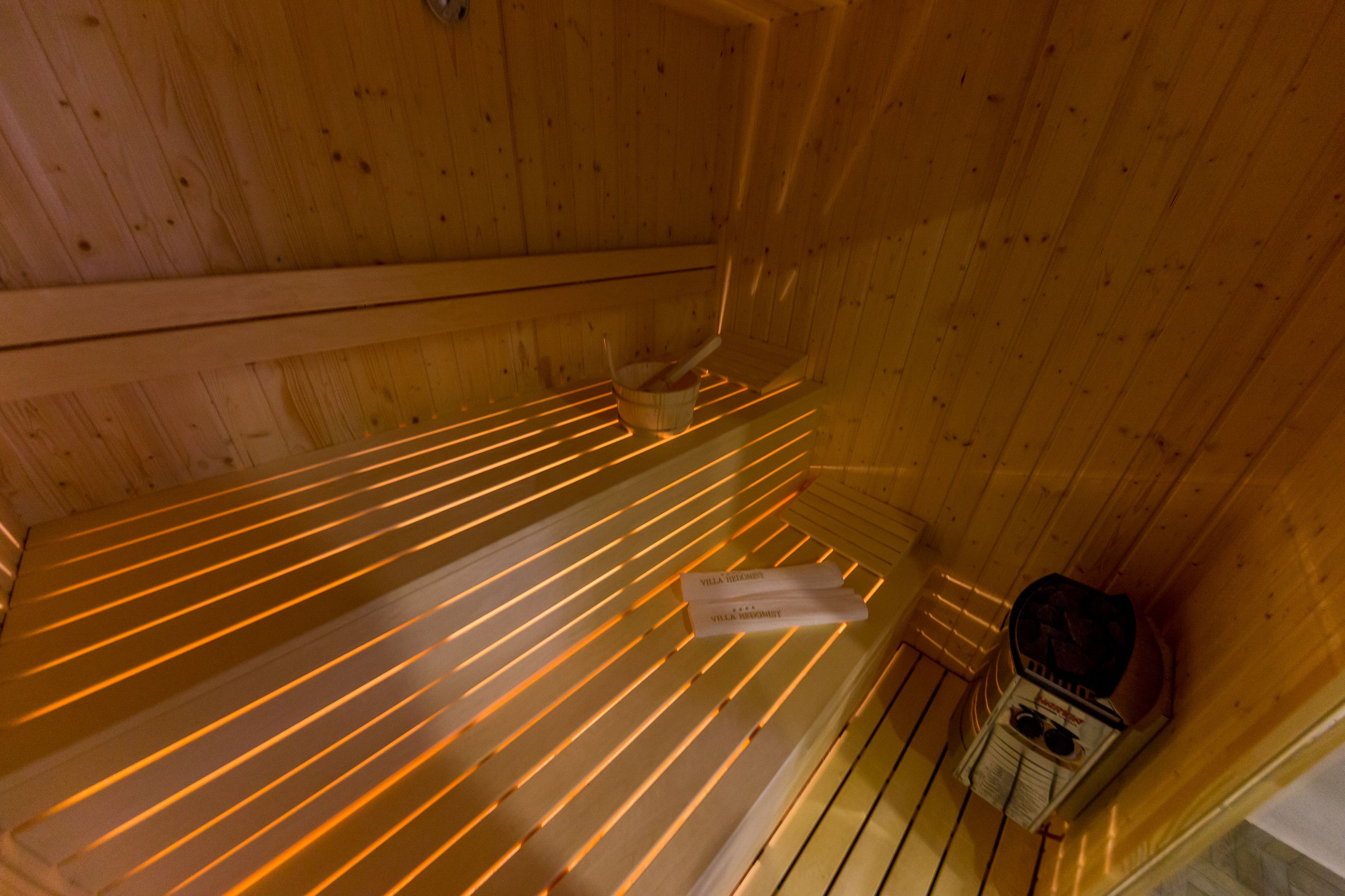 Una sauna con bancos de madera y calentador.