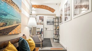 A hallway with a bench, a lamp, a bookshelf, and framed pictures on the walls. - Canto dei Servi (Florence)