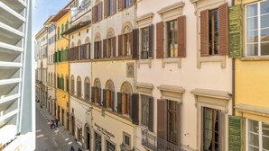 A multi-story building with balconies, arched windows, and a street view. - Canto dei Servi (Florence)