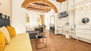 A hotel room with a bed, a TV, a wardrobe, a mirror, and a small table. - Canto dei Servi (Florence)