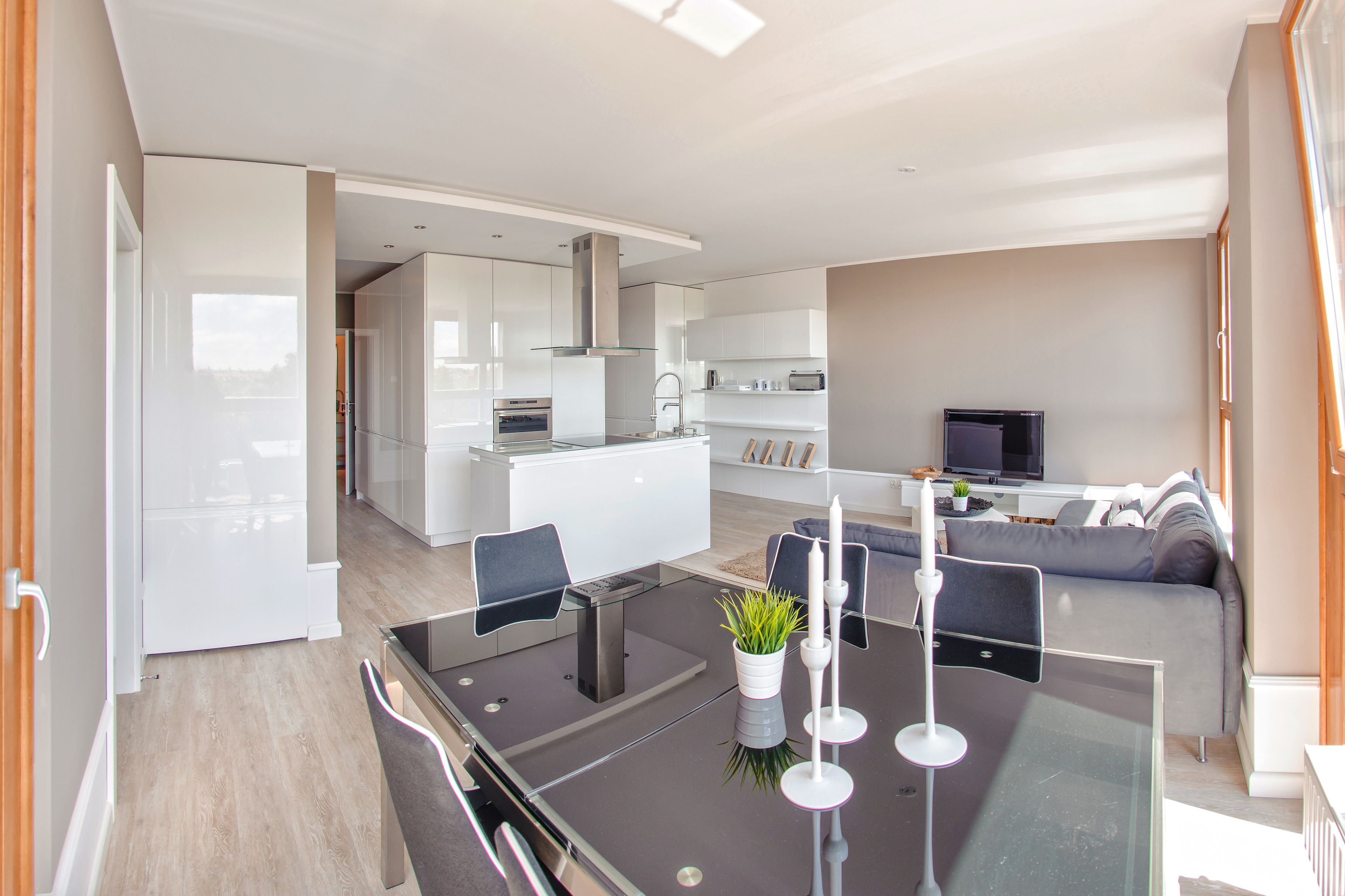 A modern living space with a kitchen, dining area, and seating area.