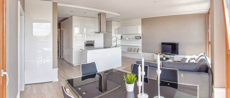 A modern living space with a kitchen, dining area, and seating area.