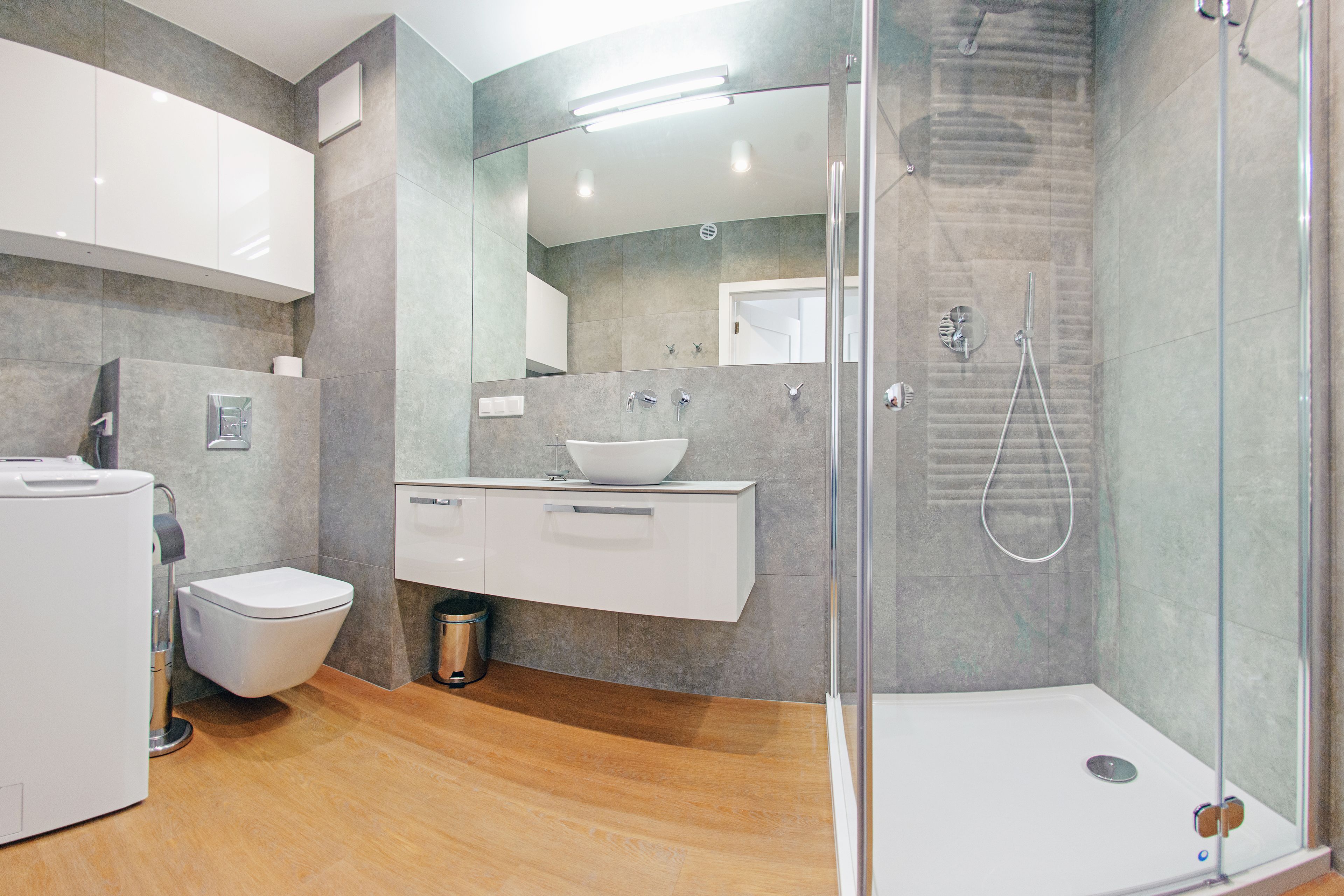 Une salle de bain moderne avec une douche à parois de verre, un lavabo blanc et des toilettes.