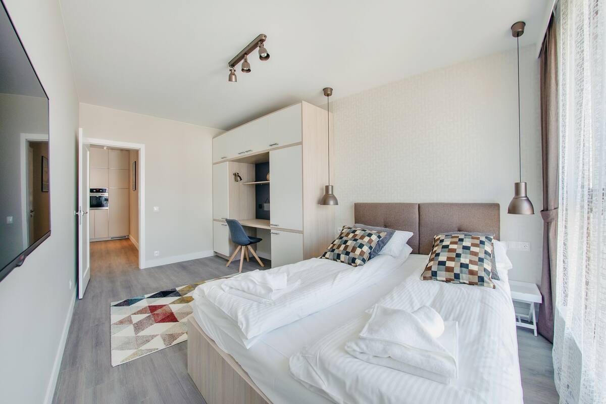 Een moderne hotelkamer met een groot bed, een bureau en een kledingkast.