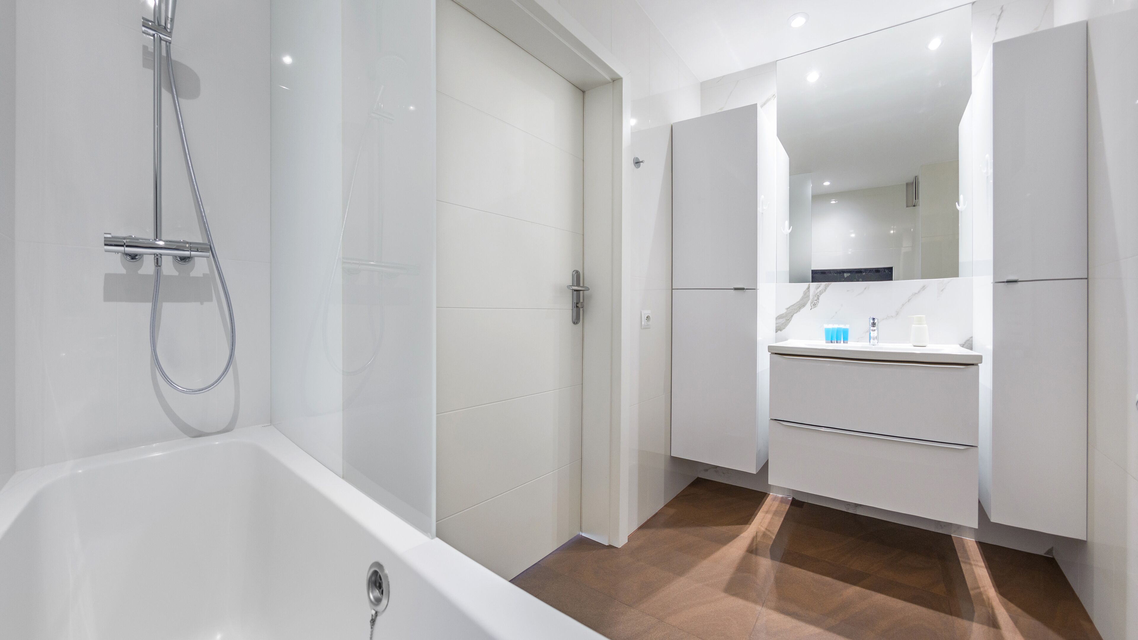A modern bathroom with a bathtub, a shower, and a vanity with a mirror.