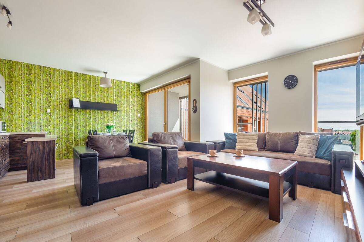 Een moderne woonkamer met een zithoek, een salontafel en een televisie.