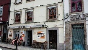 A building with a restaurant named "OM PIPAS" and a sign for "ROTA DO CRUZEIROS". - T2 suites vista rio Douro (Vila Nova de Gaia)