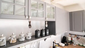 A kitchen with grey cabinets, a black countertop, and various kitchen items including jars and containers.