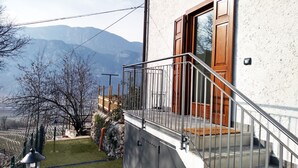 A building with a wooden door and a metal staircase leading to a balcony.