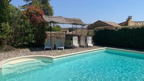 Una piscina nítida amb gandules i una paret de pedra.