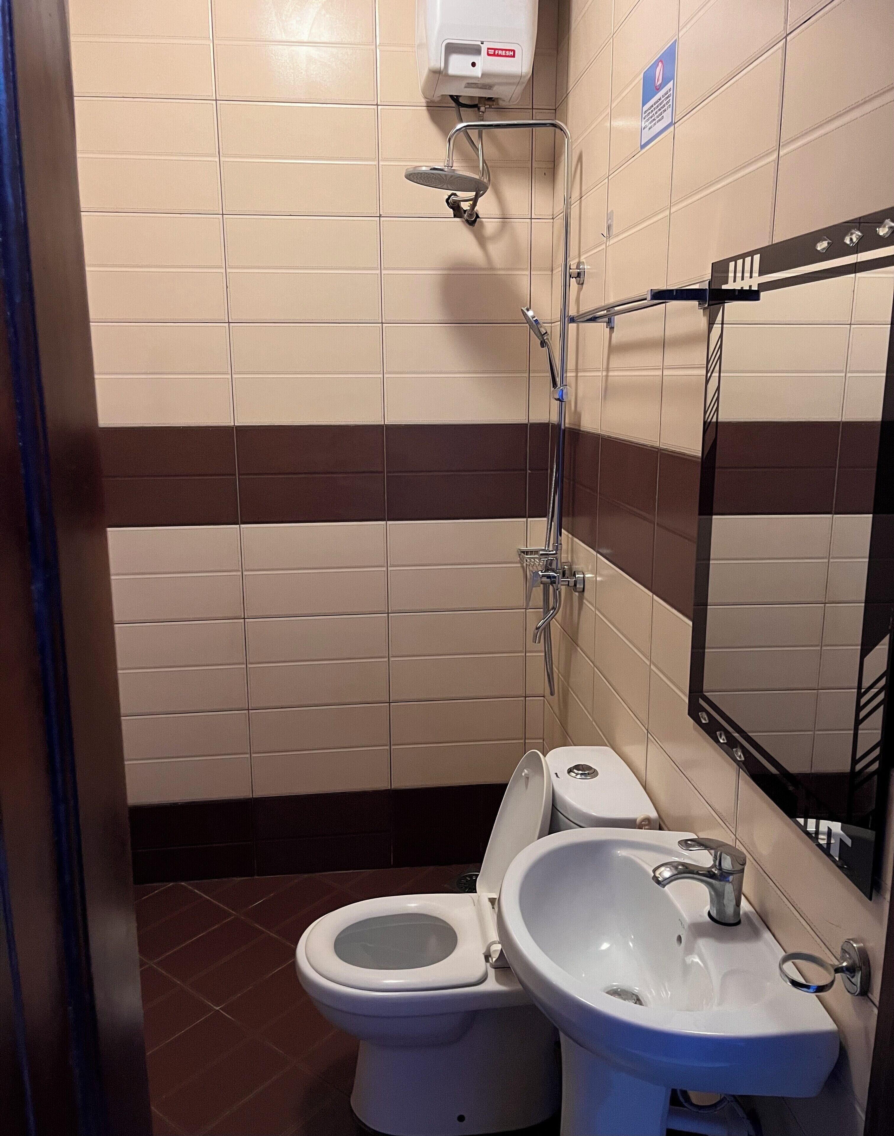 Un baño pequeño con inodoro, lavabo y ducha.