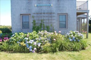 Welcome to Sandelot, a charming home with a balcony and garden surrounded by lush greenery.