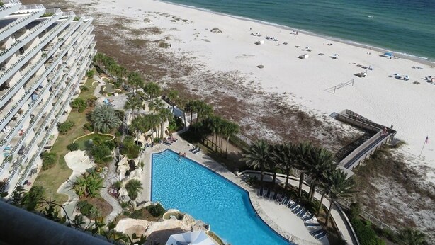Un resort con una grande piscina, spiaggia e vista sull'oceano.