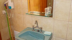 A bathroom with a sink, mirror, and a broom leaning against the wall. - Eleni's Apartments & Studios (Corfu)