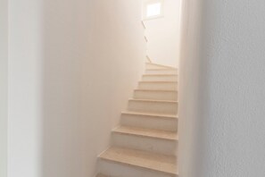 Stairs lead to an upper floor with a small window at the top.