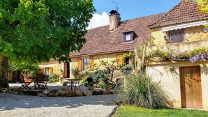 A stone house with a gravel driveway, outdoor seating, and a garden. - Les Papillons 4/6, Pool, Balcony, Garden & Courtyard, Top Location & Activities (Domme)