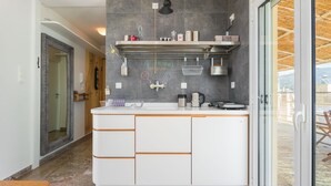 Una cocina moderna con armarios blancos, extractor de acero inoxidable y una pared de pizarra con escritura.