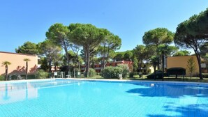 Una piscina azul cristalina rodeada de árboles y edificios.