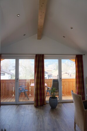 A spacious room with a large sliding glass door leading to an outdoor deck. - Bright, comfortable, and tastefully furnished apartment with a south-facing balcony (Hausham)