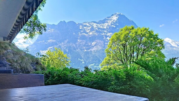 Una mesa de madera con vista a la montaña.