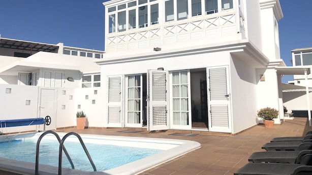 A two-story white building with a swimming pool and outdoor seating. - GREAT CENTRAL HOUSE TIAS LANZAROTE (Tías)