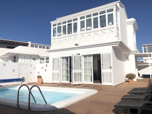 A two-story white building with a swimming pool and outdoor seating. - GREAT CENTRAL HOUSE TIAS LANZAROTE (Tías)